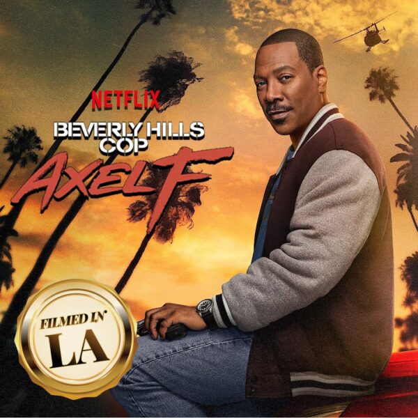 Promotional poster for Beverly Hills Cop: Axel F featuring Eddie Murphy seated against a backdrop of palm trees and an orange sunset sky, with a "Filmed in LA" gold badge in the bottom left corner and a helicopter flying in the distance. Netflix logo appears above the title.