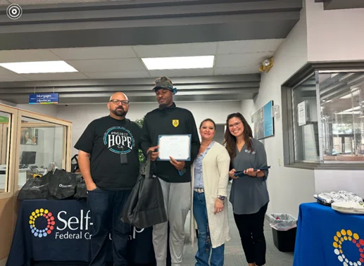Youth with Completion Certificate, standing with mentors.